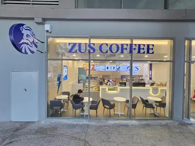 a man sitting at a table in a coffee shop at Bukit Bintang Fairlane Residence #18 Kuala Lumpur in Kuala Lumpur