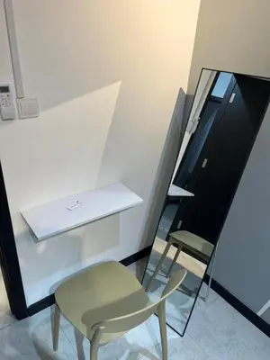 a chair sitting next to a counter and a mirror at Neu Suites 2 Room Home Stay in Kuala Lumpur