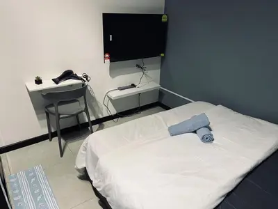 a bedroom with a bed and a desk and a television at Neu Suites Studio Home Stay in Kuala Lumpur
