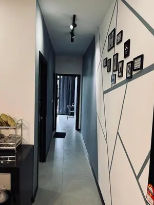 a hallway with a wall with pictures on it at Neu Suites 2 Bedroom Family Suites in Kuala Lumpur