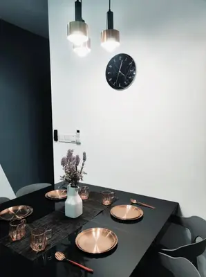 a black table with plates and a clock on the wall at Neu Suites 2 Bedroom Family Suites in Kuala Lumpur