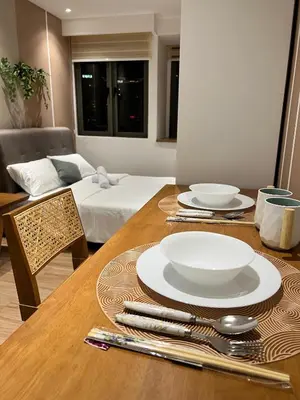 a wooden table with plates and utensils on it at Reveria city KL in Kuala Lumpur