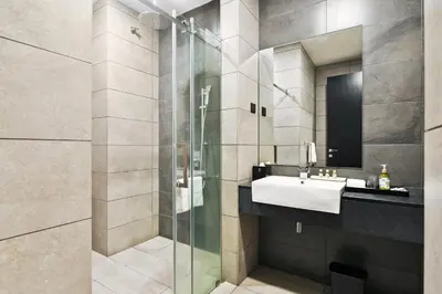 a bathroom with a sink and a glass shower at Atelier 118 Chinatown in Kuala Lumpur