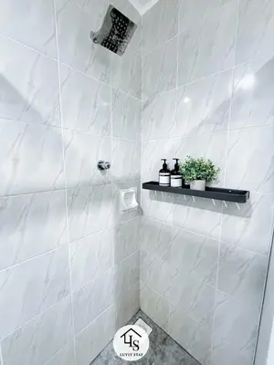 a bathroom with a shower with white tiles at Holiday Place by Luvit Stay in Kuala Lumpur