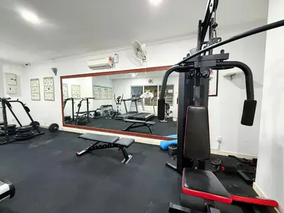 a gym with several tread machines and a mirror at Holiday Place by Luvit Stay in Kuala Lumpur