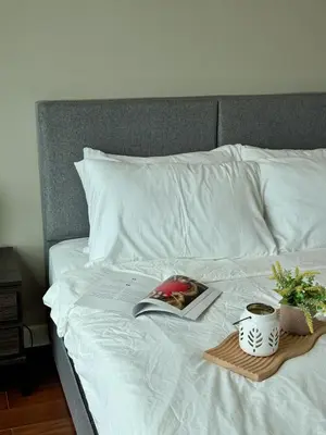 a book on a bed with a plate of flowers at DRapport APT got Bathtub & Kids Game by Iconique in Kuala Lumpur