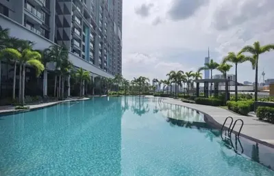 a large swimming pool with palm trees next to a building at Trion KL By HomeTaric Suite in Kuala Lumpur