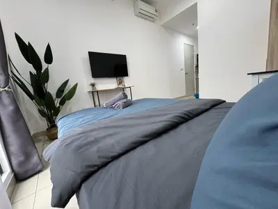 a bedroom with a large bed with a tv on the wall at Trion KL By HomeTaric Suite in Kuala Lumpur