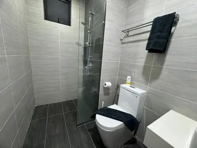 a bathroom with a toilet and a glass shower at Trion KL, Jalan Chan Sow Lin, Kuala Lumpur by One Guesthouse in Kuala Lumpur