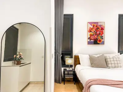 a bedroom with a mirror next to a bed at Lucentia Apartments in Kuala Lumpur