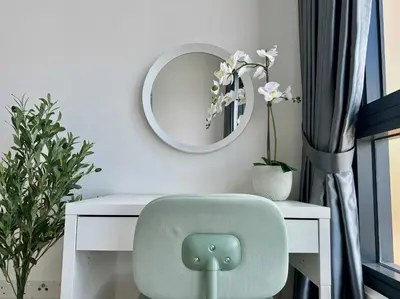 a white desk with a green chair and a mirror at Lucentia Apartments in Kuala Lumpur