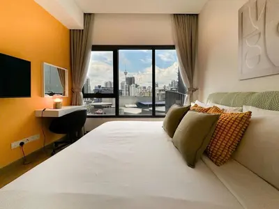 a bedroom with a large bed with a large window at Lucentia Apartments in Kuala Lumpur