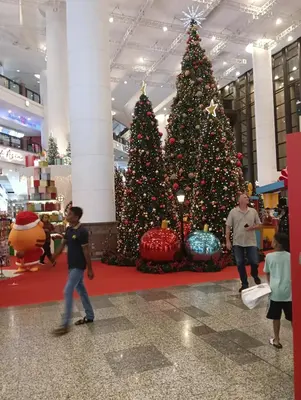 a christmas tree in a mall with children walking by it at Services Star Hotel Suites At Times Square in Kuala Lumpur
