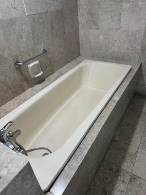a white bath tub in a bathroom with a tile wall at Services Star Hotel Suites At Times Square in Kuala Lumpur