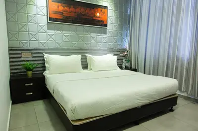 a bed with white sheets and pillows in a room at M Design Hotel @ Shamelin Perkasa in Kuala Lumpur