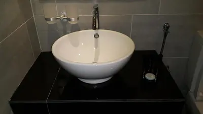 a bathroom with a white sink on a black counter at M Design Hotel @ Shamelin Perkasa in Kuala Lumpur