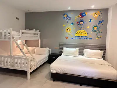 a bedroom with two bunk beds and a wall mural at M Design Hotel @ Shamelin Perkasa in Kuala Lumpur