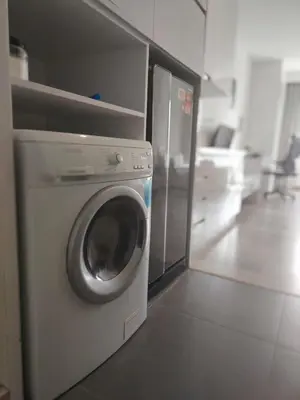 a washing machine in a kitchen with a refrigerator at One bukit ceylon Mardeka Tower View in Kuala Lumpur
