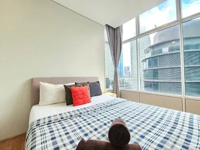 a bedroom with a bed and a large window at The Sky Suites KLCC by the Park in Kuala Lumpur