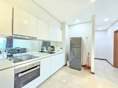 a kitchen with white cabinets and a stainless steel refrigerator at The Sky Suites KLCC by the Park in Kuala Lumpur