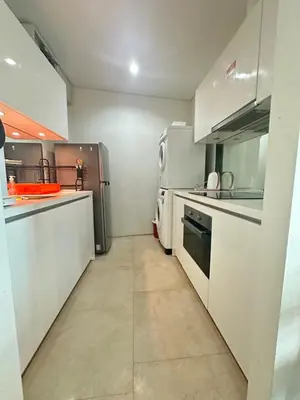 a large kitchen with white cabinets and appliances at Vortex Suites KLCC by Angel in Kuala Lumpur
