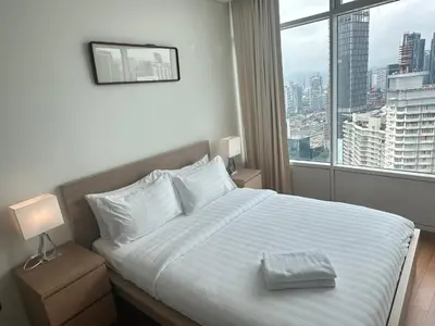 a bedroom with a bed with a view of a city at Vortex Suites KLCC by Angel in Kuala Lumpur