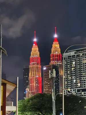 two tall towers lit up in red lights in a city at Regalia Skypool KLCC Friendly Hostel in Kuala Lumpur