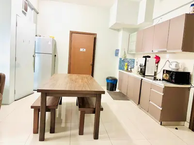 a kitchen with a wooden table and a refrigerator at Regalia Skypool KLCC Friendly Hostel in Kuala Lumpur