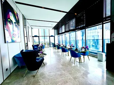 a restaurant with blue chairs and tables and windows at The KLCC At Star SKY Pools in Kuala Lumpur