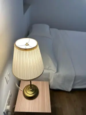 a lamp on a table next to a bed at The Establishment Bangsar #19 by Ouki in Kuala Lumpur