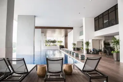 a lobby with a pool and three chairs at The Establishment Bangsar #19 by Ouki in Kuala Lumpur