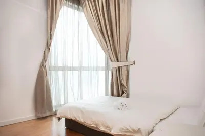 a bed in a room with a large window at MyHabitat Residences in Kuala Lumpur