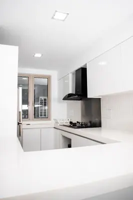 a white kitchen with white cabinets and a window at MyHabitat Residences in Kuala Lumpur