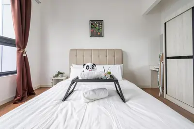 a bedroom with a bed with a table on it at Kuala Lumpur Skyline CityView Comfort Home in Kuala Lumpur
