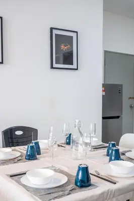 a table with blue and white plates and wine glasses at Kuala Lumpur Skyline CityView Comfort Home in Kuala Lumpur