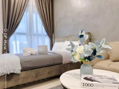 a bedroom with a bed and a table with a vase of flowers at 5 STAR Homestay 3R3B KL View Trion TRX Velocity in Kuala Lumpur