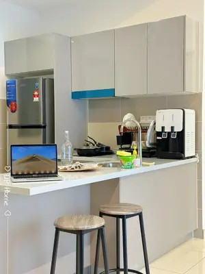 a kitchen with a laptop on a counter with two stools at 5 STAR Homestay 3R3B KL View Trion TRX Velocity in Kuala Lumpur