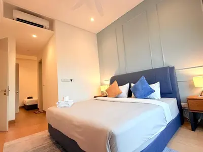 a bedroom with a large bed with blue pillows at Stylish Apartment at Lucentia residence BBCC Lalaport in Kuala Lumpur