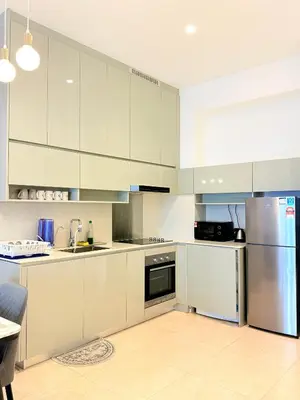 a kitchen with white cabinets and a stainless steel refrigerator at Stylish Apartment at Lucentia residence BBCC Lalaport in Kuala Lumpur