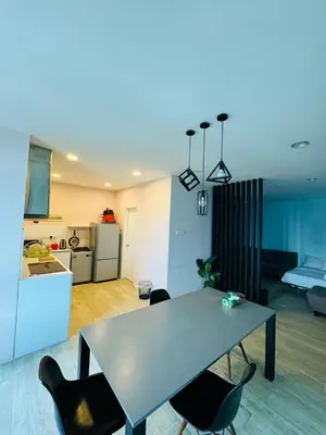 a living room with a table and chairs and a kitchen at Taragon Standard Homestay in Kuala Lumpur