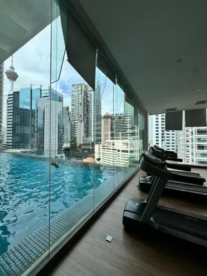 a gym with a swimming pool in a building at 1 Bukit Ceylon Kuala Lumpur in Kuala Lumpur