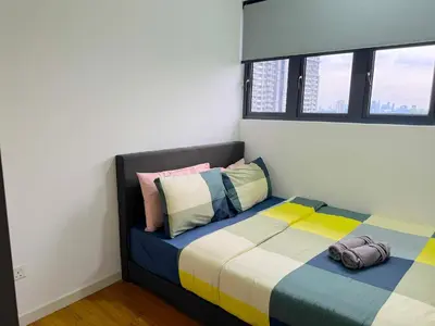 a bedroom with a bed with colorful sheets and pillows at M Vertica Cheras by RASBO Galaxy Suites in Kuala Lumpur