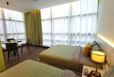 a hotel room with two beds and a table and chairs at Weekly Monthly Stay - Bangsar Trade Centre Territory in Kuala Lumpur