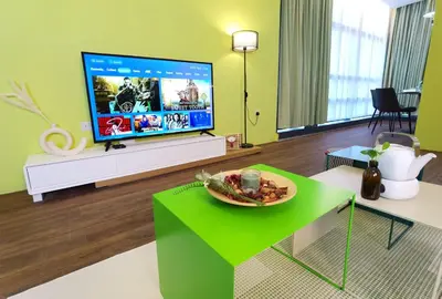 a living room with a flat screen tv and a table at Weekly Monthly Stay - Bangsar Trade Centre Territory in Kuala Lumpur