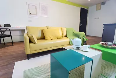 a living room with a yellow couch and a table at Weekly Monthly Stay - Bangsar Trade Centre Territory in Kuala Lumpur
