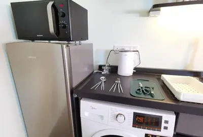 a kitchen with a stove and a microwave on top of a refrigerator at Weekly Monthly Stay - Bangsar Trade Centre Territory in Kuala Lumpur