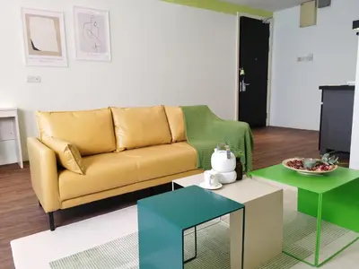 a living room with a yellow couch and two tables at Weekly Monthly Stay - Bangsar Trade Centre Territory in Kuala Lumpur