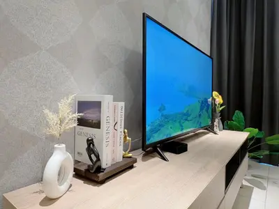a flat screen tv sitting on top of a desk at KL V Residence I with Balcony I 吉隆坡双威伟乐城民宿-附有阳台 I Walking distance to MRT & Mall & Nanjing Street I 马中英服务 I Malay English Chinese in Kuala Lumpur