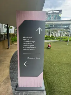 a sign in the grass in front of a building at Sunway Velocity in Kuala Lumpur