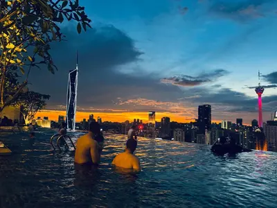 a group of people sitting in the water with a city skyline at AXON Bukit Bintang Suites KL in Kuala Lumpur